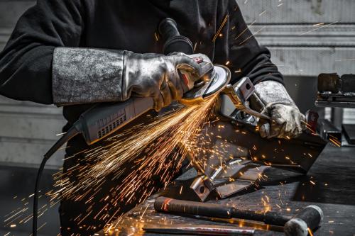 View of worker grinding a piece of metal